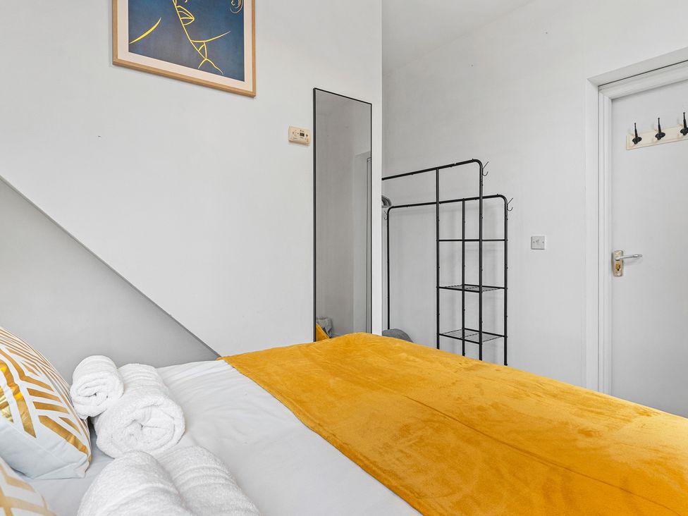 A bedroom with a bed and shelves at The Goldsmith Birmingham City Apartment Birmingham