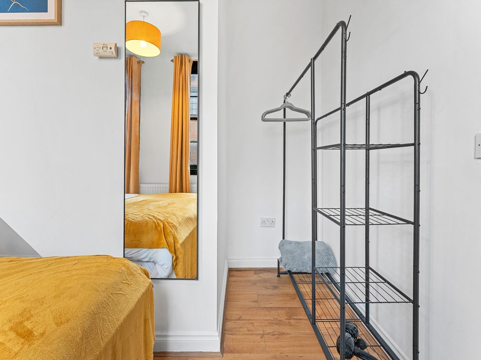 A bedroom with a mirror and a clothes rack at The Goldsmith Birmingham City Apartment Birmingham