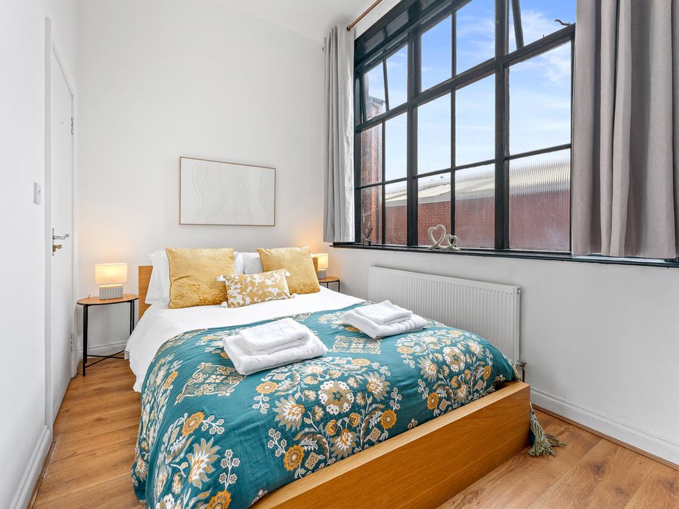 A bedroom with a bed and lamps at The Goldsmith Birmingham City Apartment Birmingham
