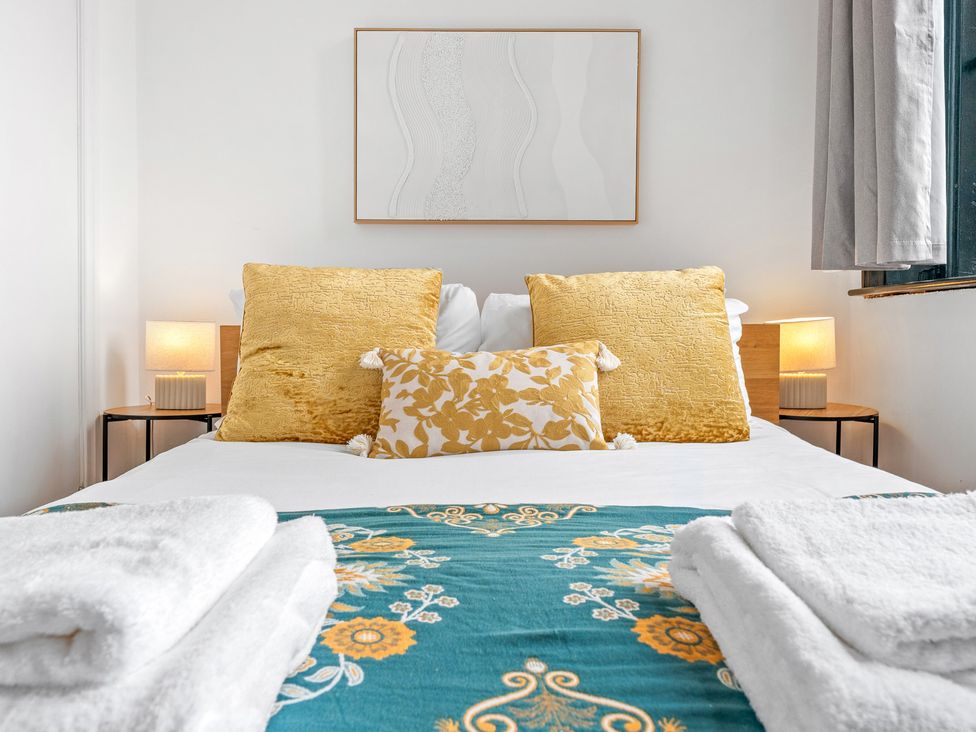 A bedroom with a bed and decorative pillows at The Goldsmith Birmingham City Apartment in Birmingham