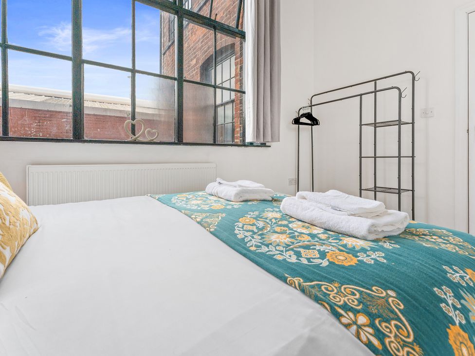 A bedroom with a bed and towels at The Goldsmith Birmingham City Apartment Birmingham