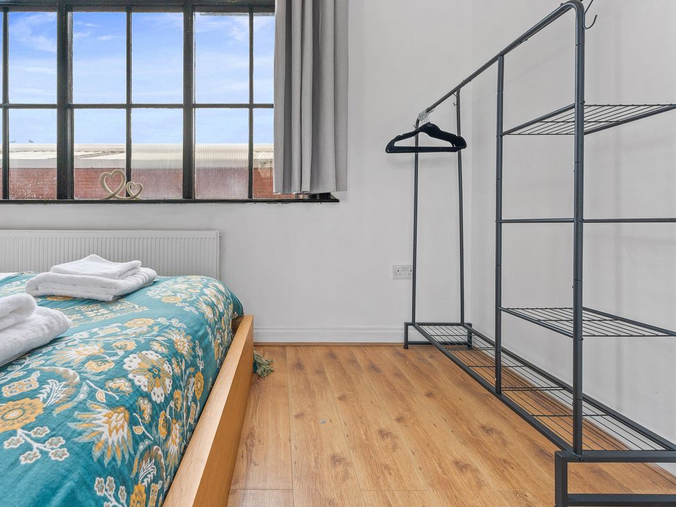 A bedroom with a bed and shelves at The Goldsmith Birmingham City Apartment Birmingham