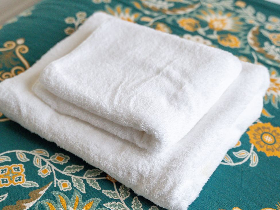 White towels stacked on a fabric surface at The Goldsmith Birmingham City Apartment Birmingham
