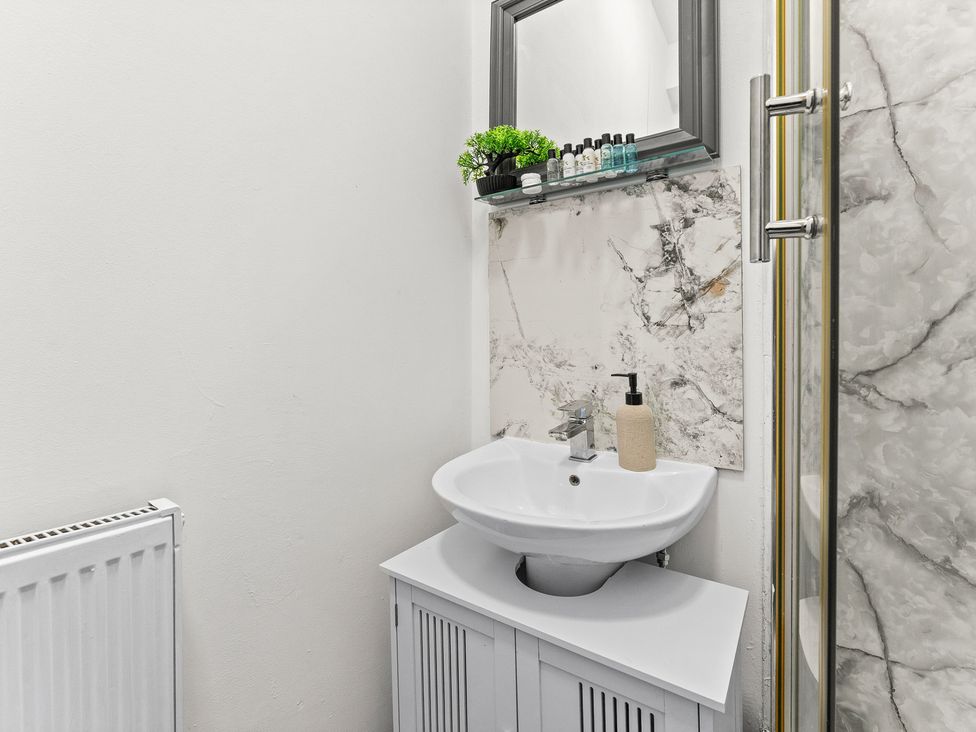 A bathroom featuring a sink with a mirror and a shower at The Goldsmith Birmingham City Apartment Birmingham