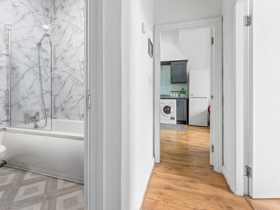 A bathroom with a shower and washing machine at The Goldsmith Birmingham City Apartment in Birmingham