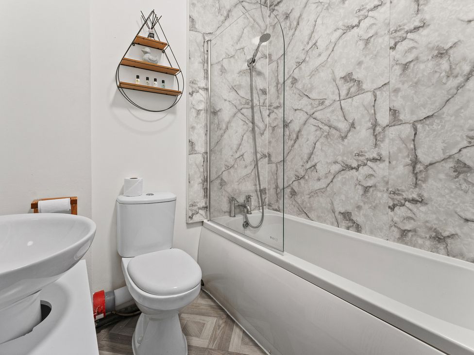 A bathroom with a bathtub and a toilet at The Goldsmith Birmingham City Apartment Birmingham