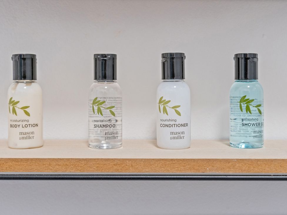 Bottle of body lotion shampoo conditioner and shower gel at The Goldsmith Birmingham City Apartment Birmingham