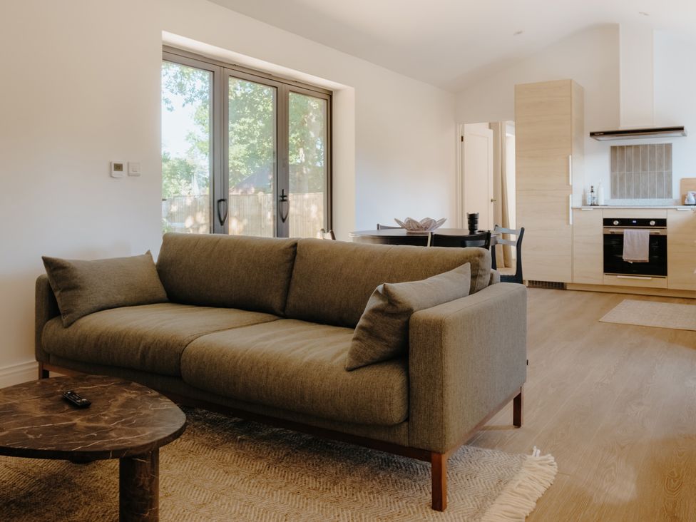 A living room with a sofa and coffee table at Baldslow Stables in Battle near Hastings