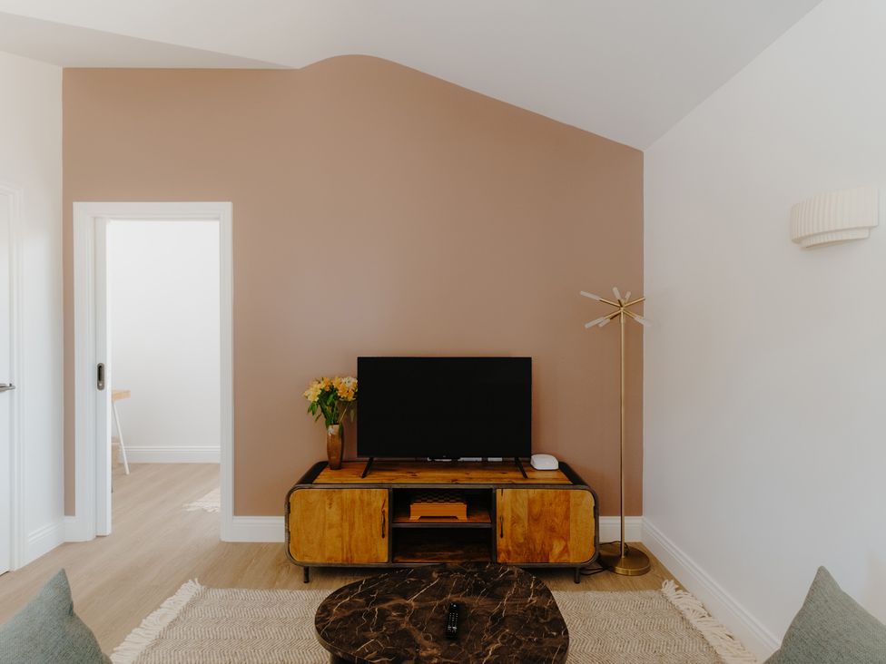 A living room with a television and media console at Baldslow Stables in Battle near Hastings