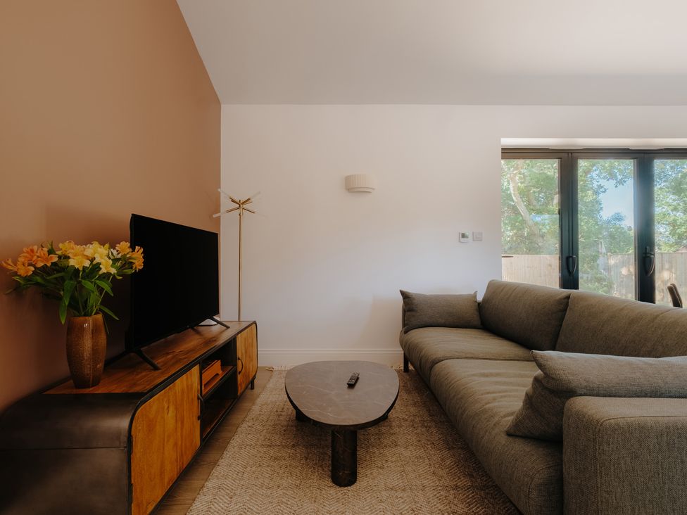 A living room with a sofa and coffee table at Baldslow Stables in Battle near Hastings