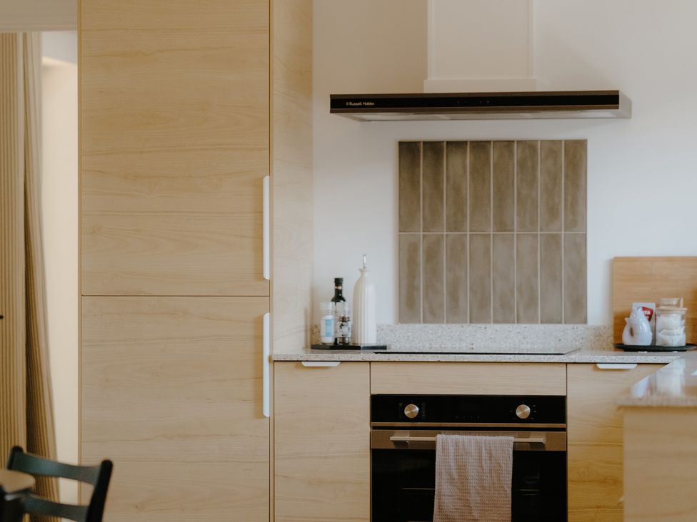 A kitchen with a fridge, oven, and countertop at Baldslow Stables in Battle near Hastings