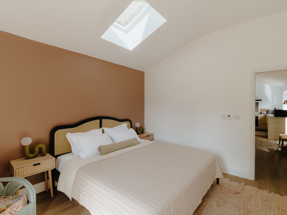 A bedroom featuring a bed and bedside tables at Baldslow Stables in Battle near Hastings
