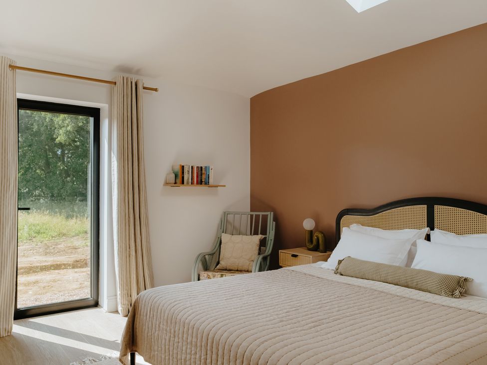 A bedroom with a bed and window at Baldslow Stables in Battle near Hastings