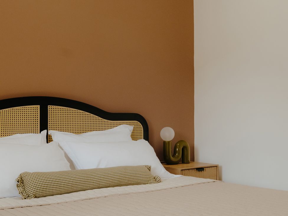 A bedroom featuring a bed with pillows and a lamp at Baldslow Stables in Battle near Hastings