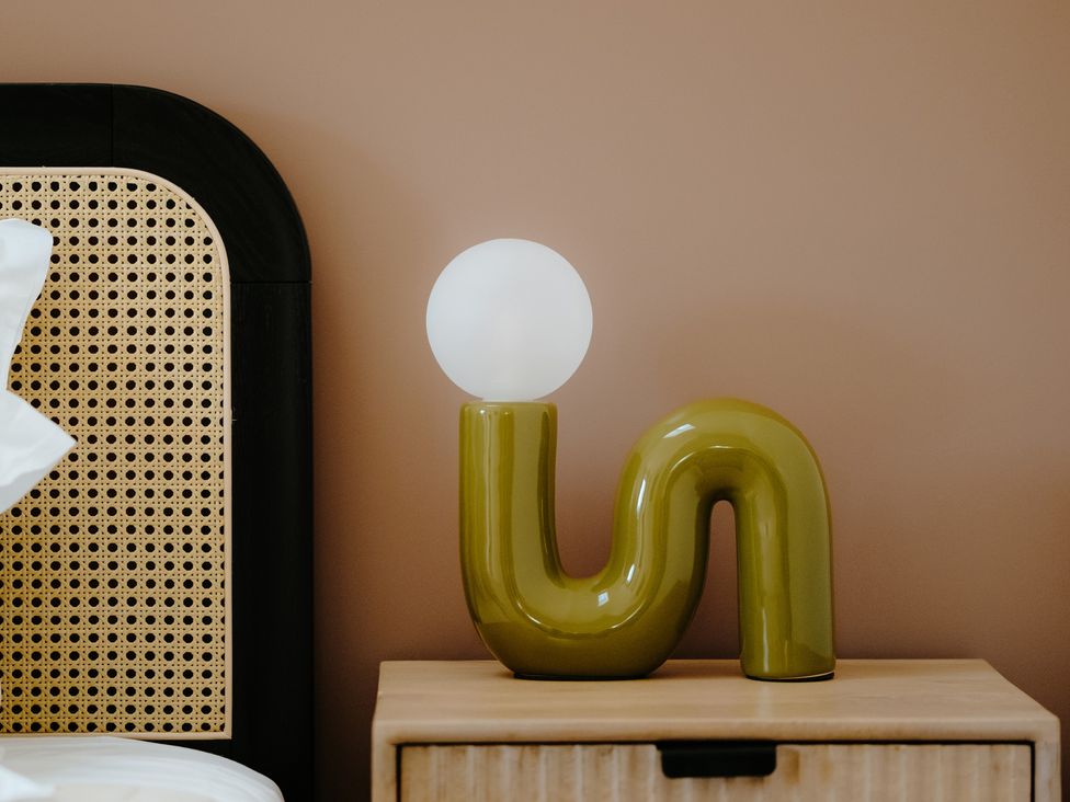 A lamp on a nightstand in a bedroom at Baldslow Stables in Battle near Hastings