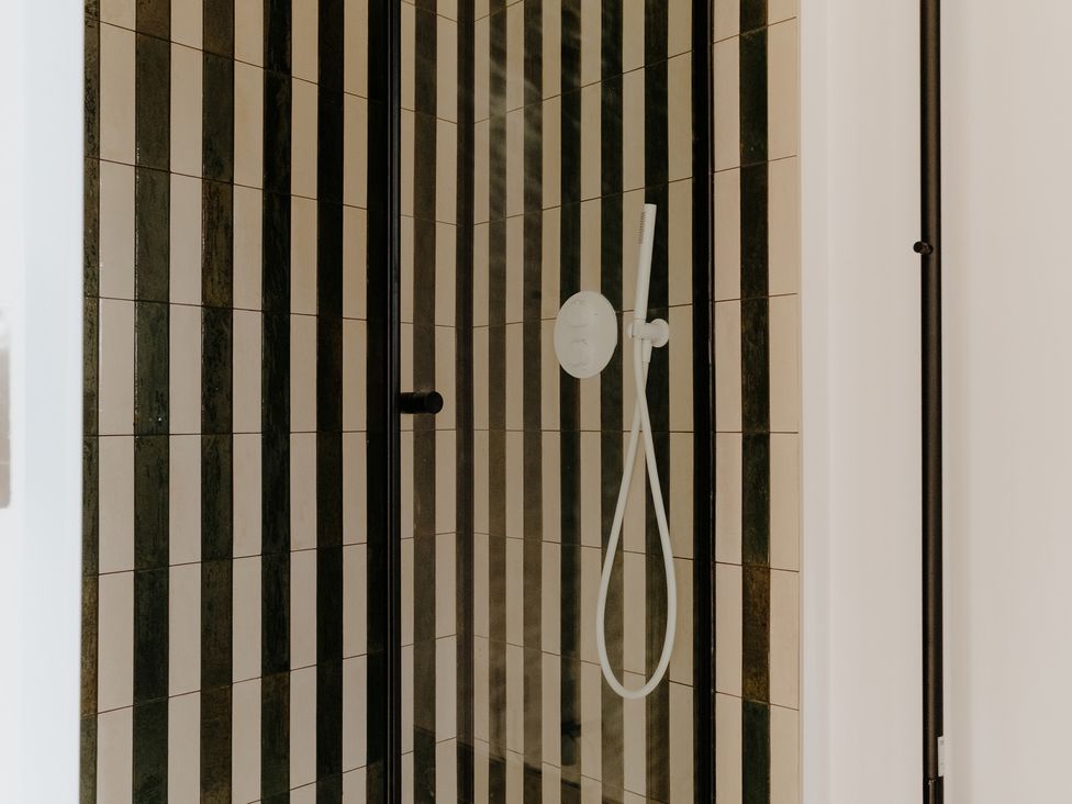 A shower with striped tiles at Baldslow Stables in Battle near Hastings