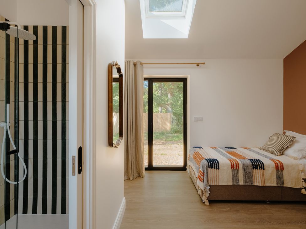 A bedroom with a bed and shower at Baldslow Stables in Battle near Hastings