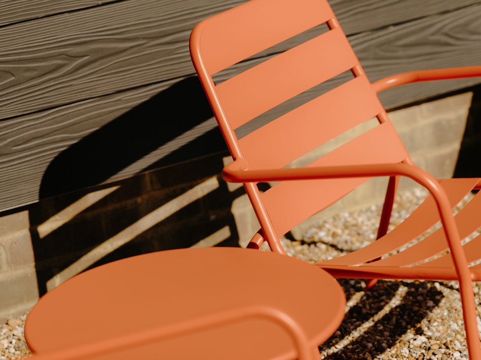 A chair and table in an outdoor space at Baldslow Stables in Battle near Hastings