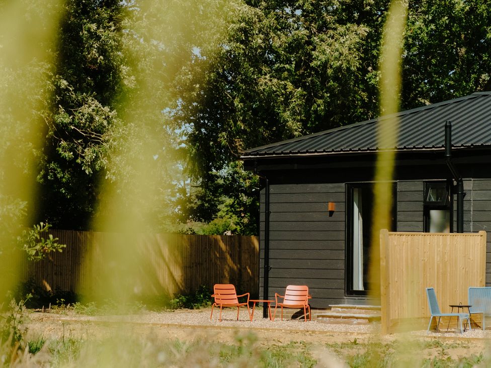 An outdoor setting with a house and chairs at Baldslow Stables near Battle