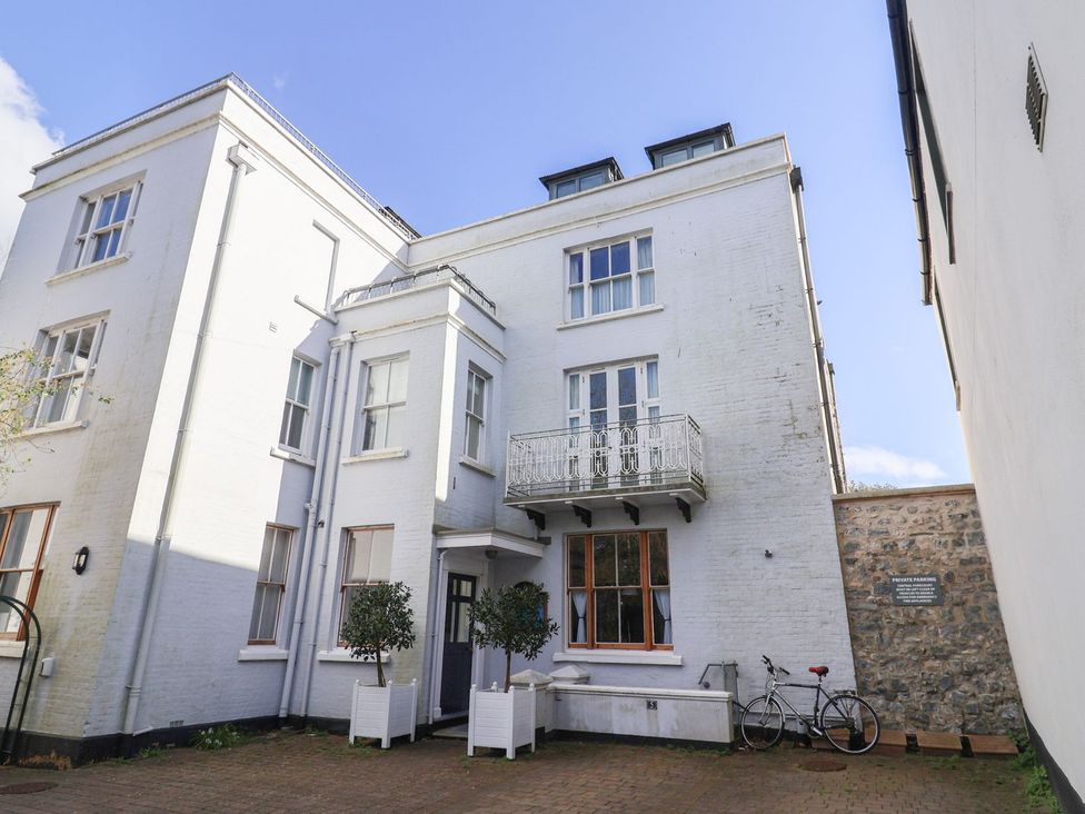 An outdoor view of a building with a balcony and trees at 2 St. Michaels House Lyme Regis