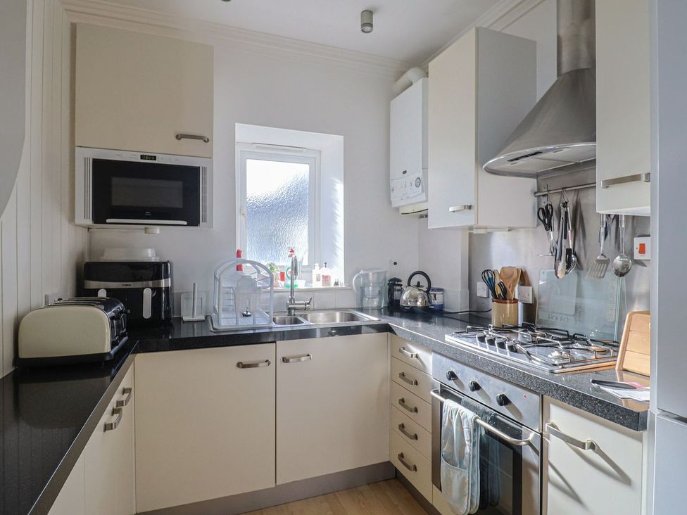 A kitchen with appliances and a window at 2 St. Michaels House in Lyme Regis