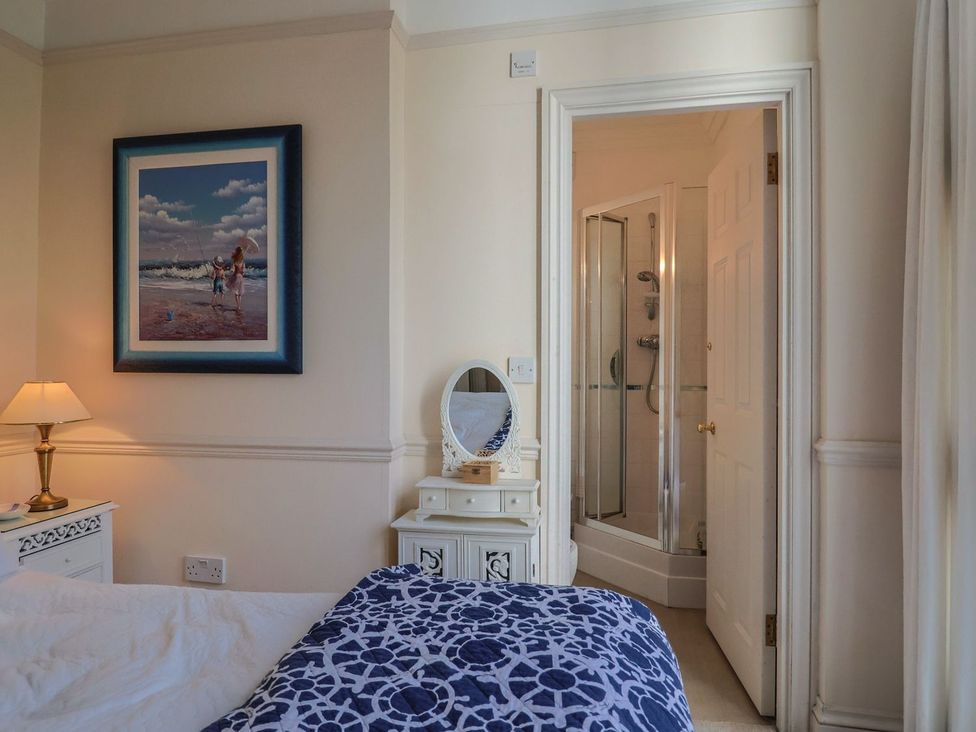 A bedroom with a bed, bedside table, and shower at 2 St. Michaels House in Lyme Regis