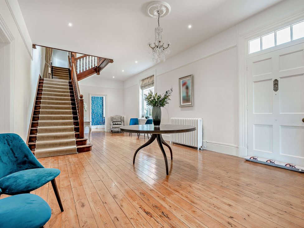 A hallway with a staircase and a table at Staunton Park in Leominster