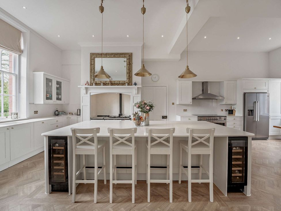 A kitchen with a large island and bar stools at Staunton Park in Leominster