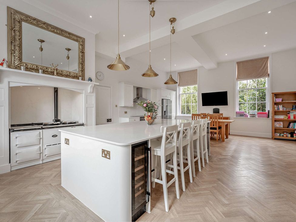 A kitchen with an island and bar stools at Staunton Park in Leominster