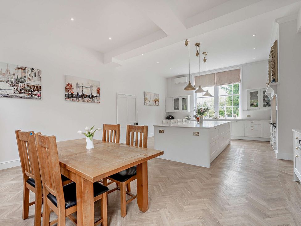 A kitchen with a table and chairs and a kitchen island at Staunton Park in Leominster
