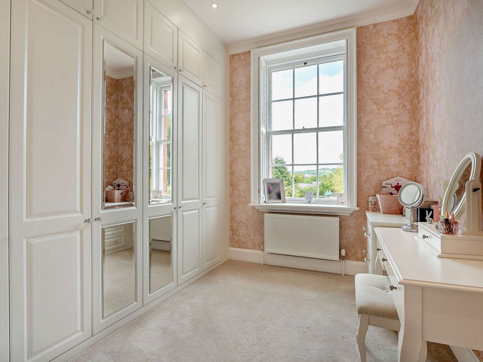 A bedroom with a wardrobe and desk at Staunton Park in Leominster