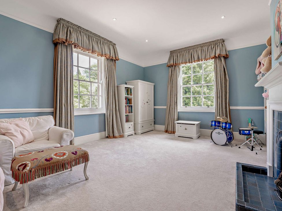 A playroom with a sofa, bookshelf, and drum set at Staunton Park in Leominster