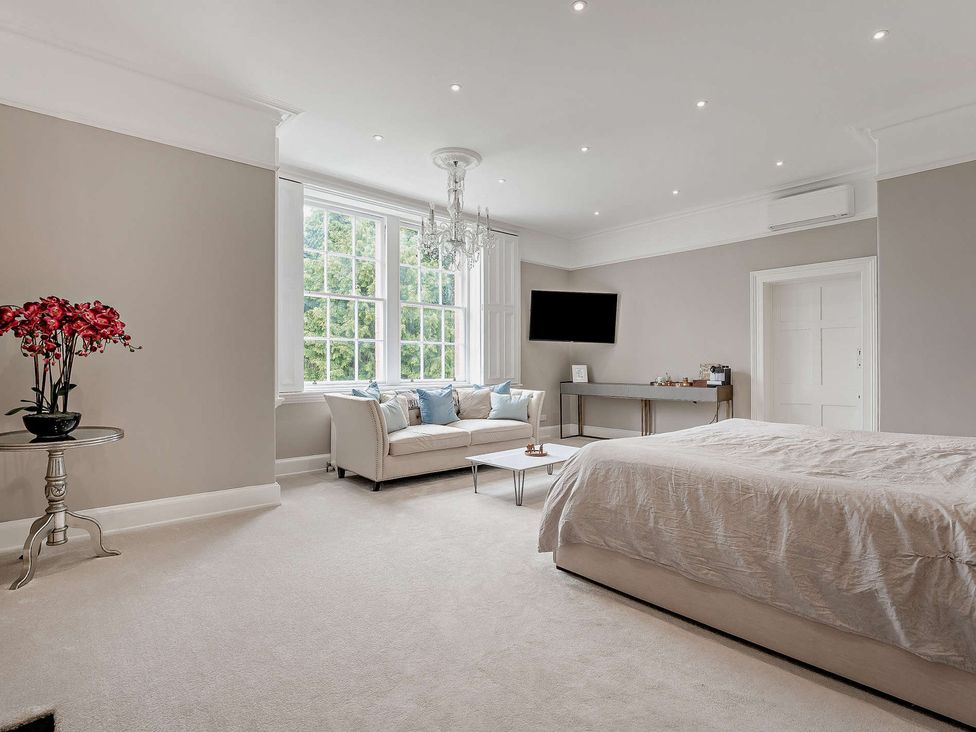A bedroom with a bed and sofa at Staunton Park in Leominster