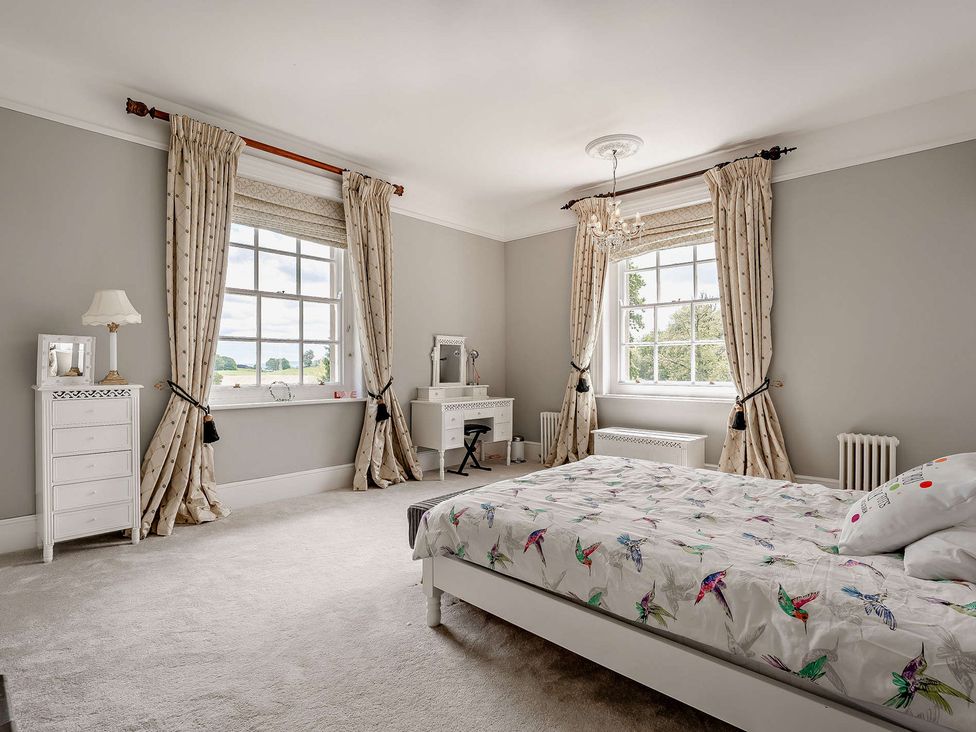 A bedroom with a bed and windows at Staunton Park in Leominster