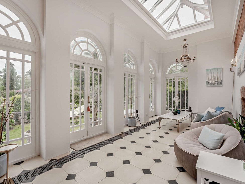 A conservatory with large windows and a sofa at Staunton Park in Leominster