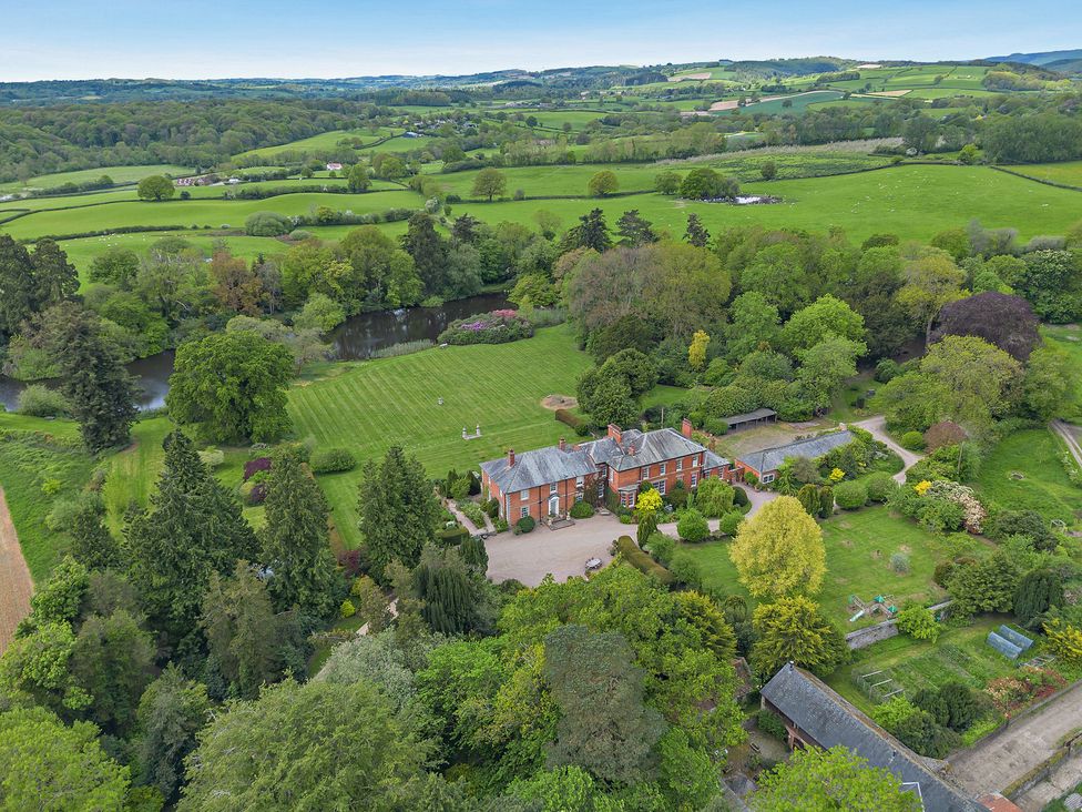 An aerial view of a house with a garden and pond at Staunton Park in Leominster