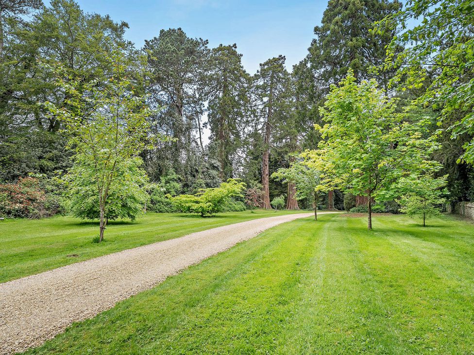 A garden with a gravel path and trees at Gate House Leominster