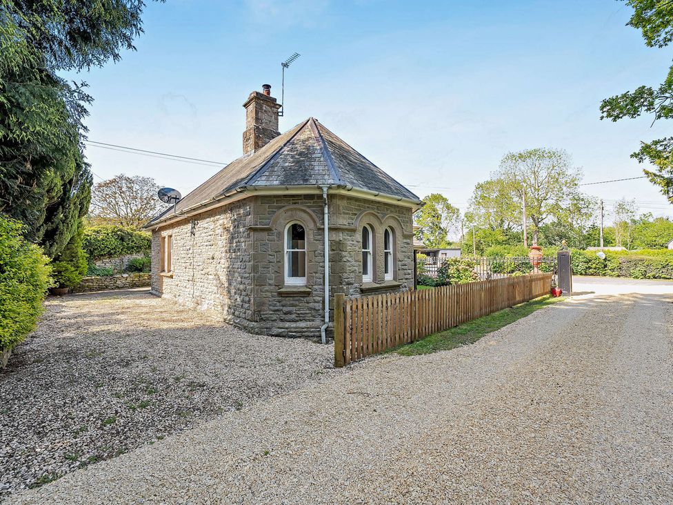 A house with a fence and gravel driveway at Gate House in Leominster