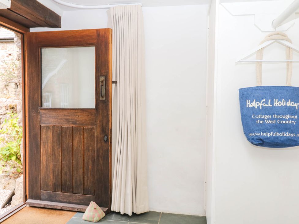An entrance with a wooden door and a bag at The Hayloft at Manaton