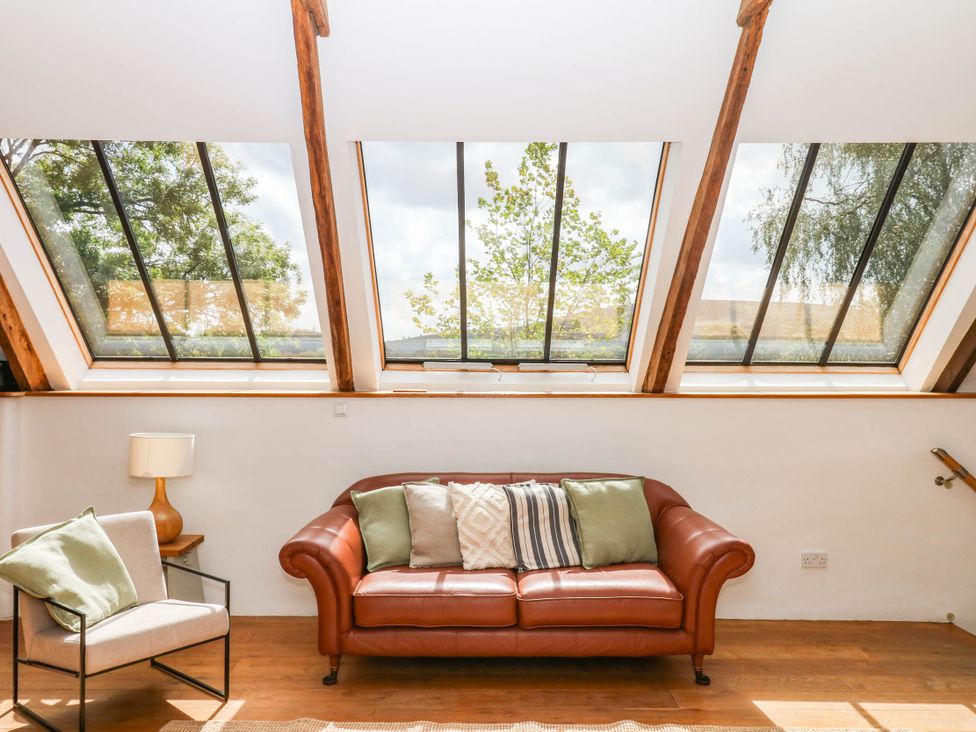 A living room with a sofa and armchair at The Hayloft at Manaton