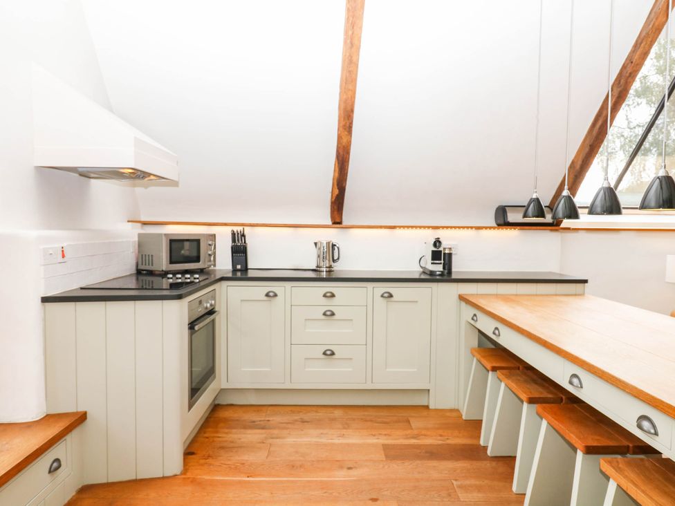 A kitchen with appliances and a dining table at The Hayloft at Manaton