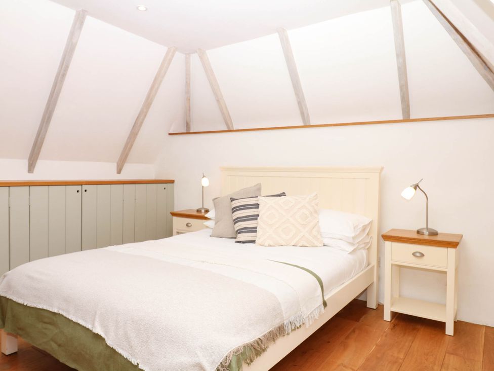 A bedroom with a bed and bedside table at The Hayloft at Manaton