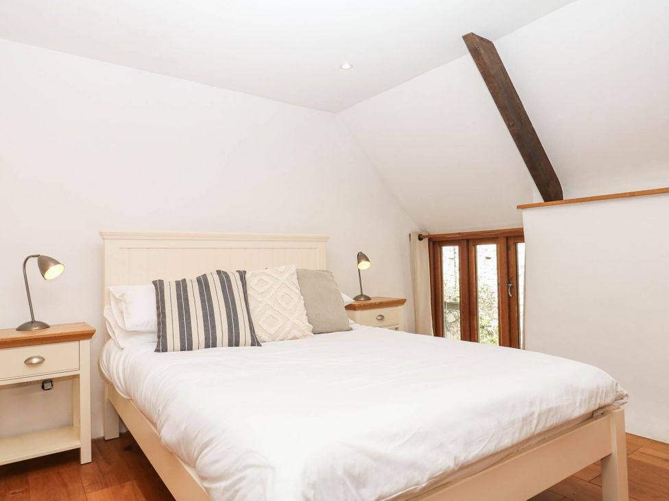 A bedroom with a bed and bedside tables at The Hayloft at Manaton