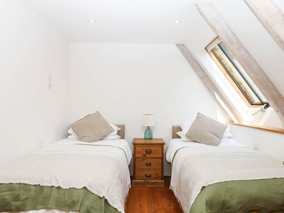A bedroom with two beds and a window at The Hayloft at Manaton