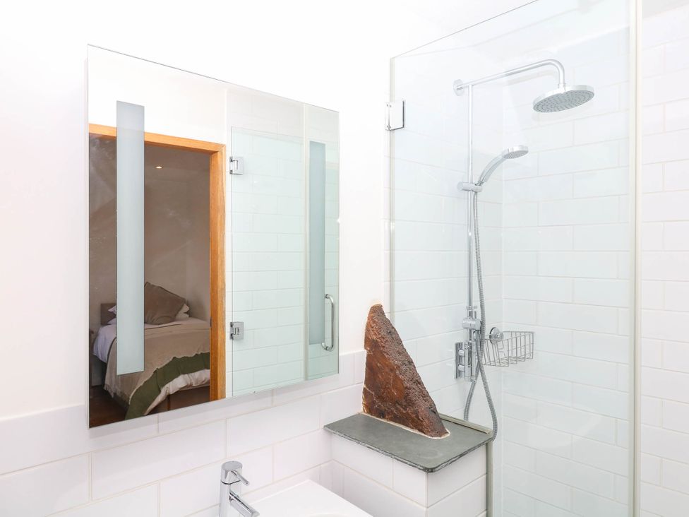 A bathroom with a shower and mirror at The Hayloft at Manaton