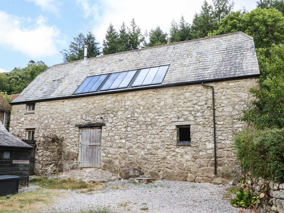 A stone building with windows and a gravel path at The Hayloft at Manaton