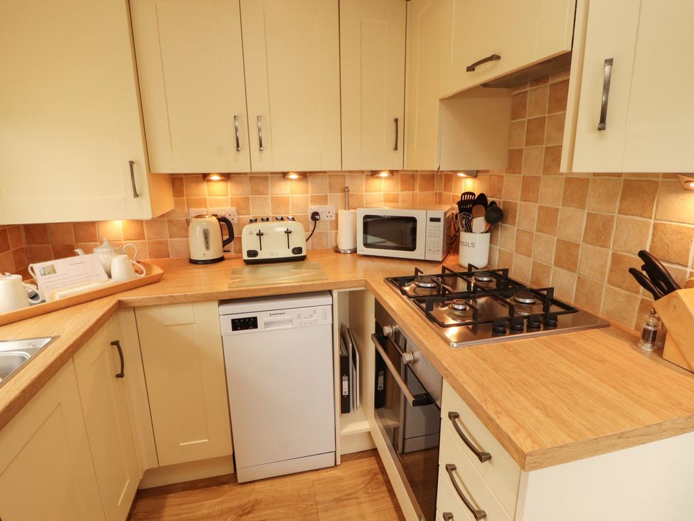 A kitchen with a gas stove and microwave at The Orchard in Levens