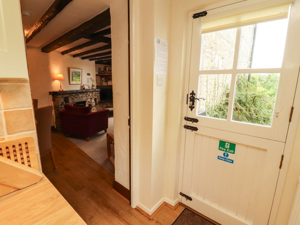 An entrance hall with a door and view to a living room at The Orchard in Levens