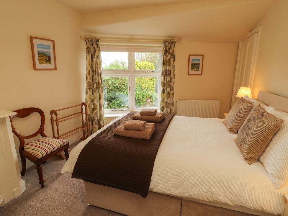 A bedroom with a bed and chair at The Orchard in Levens