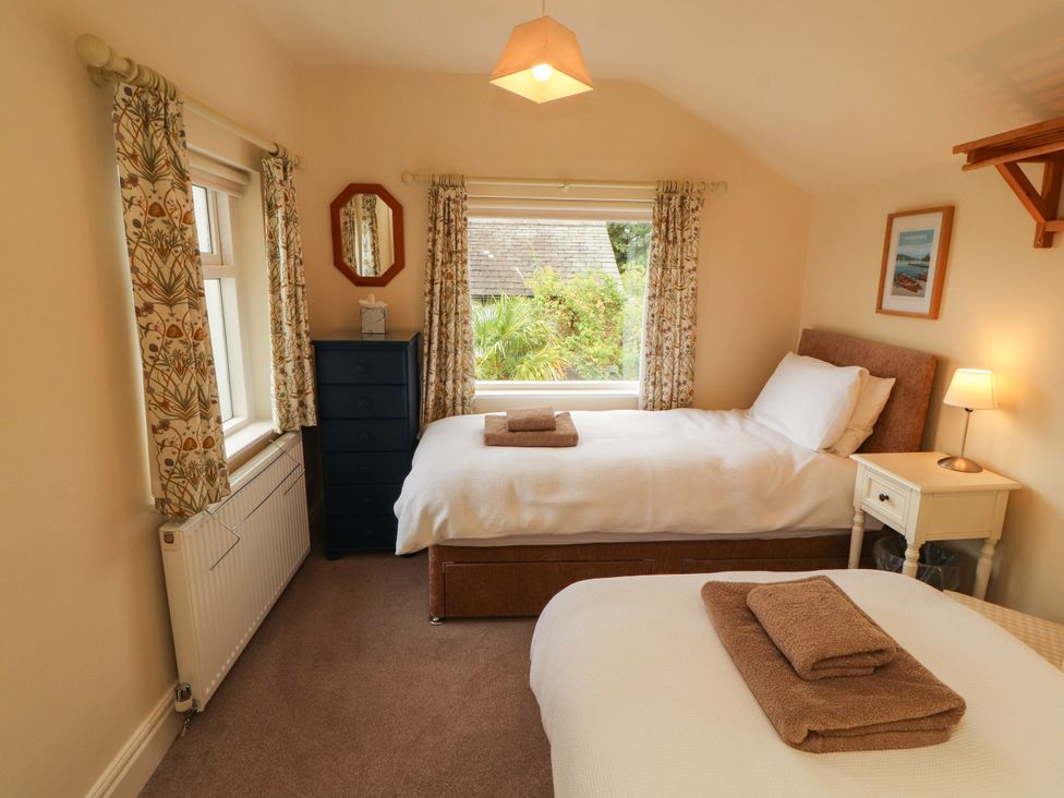 A bedroom with two beds and a nightstand at The Orchard in Levens